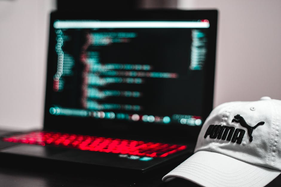 A computer screen displaying a code editor with multiple lines of programming script visible on the right side, featuring syntax highlighting with green, blue, red, and white text. The left side of th
