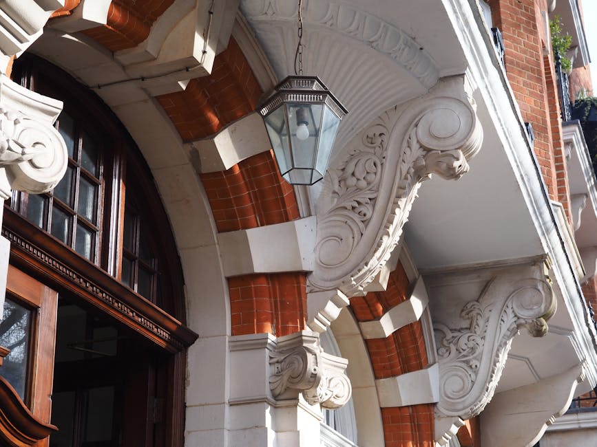 Inside a property, a team from Storage Knightsbridge is engaged in the home relocation process, carefully loading furniture and boxed items into a blue moving van parked on the pavement outside. The i